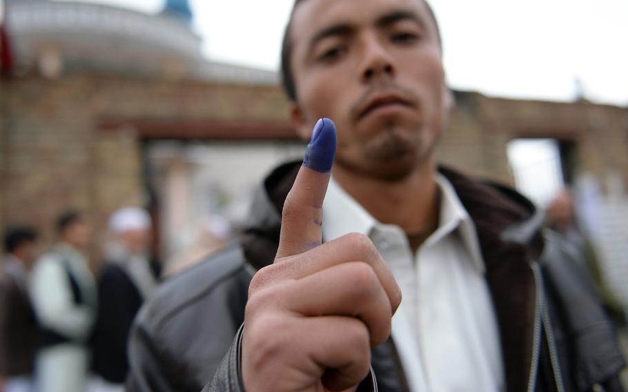 Twenty-two-year-old Kabul resident Habib displays his ink-stained finger after voting at a mosque during the national elections on Saturday, April 5, 2014.