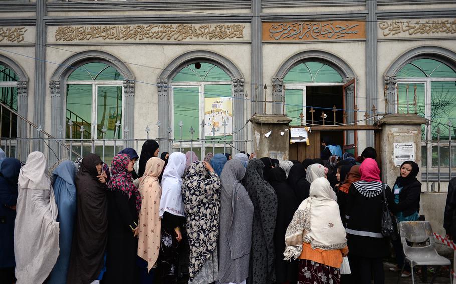 Afghan women line up outside a polling station at a mosque in Kabul on Saturday, April 5, 2014. Long lines of Afghans, including women, often stretched for blocks early on election day.