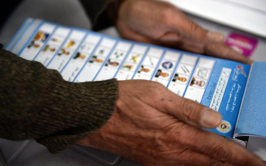 An election worker prepares a stack of ballots before opening the polls at a station in Kabul on Saturday, April 5, 2014. Voters were choosing a successor to President Hamid Karzai.