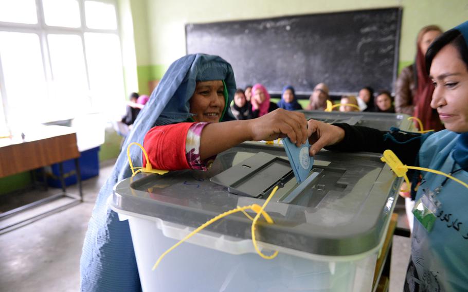 An Afghan woman casts the last ballot at a high school in central Kabul during the national elections held on Saturday, April 5, 2014. Women made up a significant part of the turnout at polling stations across the city.