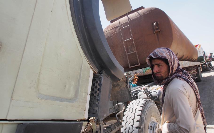 A trucker does maintenance on his truck in Kabul. Trucking officials say attacks on their convoys, especially those delivering fuel and goods to coalition military bases, have skyrocketed in the past year.