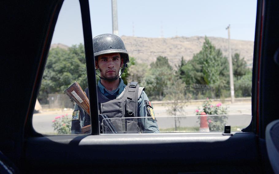 An Afghan uniformed policeman mans an election day checkpoint along the highway between Kabul and Wardak province on June 14, 2014. Security was high as the Taliban vowed to try to disrupt the election.