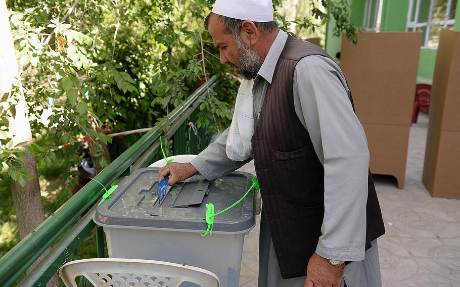 An Afghan man casts his ballot at a polling station in Wardak province, Afghanistan. Multiple rockets or mortars landed nearby during morning voting in the city. 
