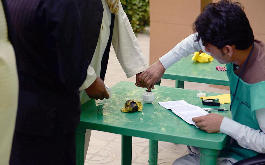 An election worker dips a voter's finger in ink to prevent fraud at a polling station in Wardak province, Afghanistan. The second round of voting seemed to see a lower turnout than the initial election on April 5.

