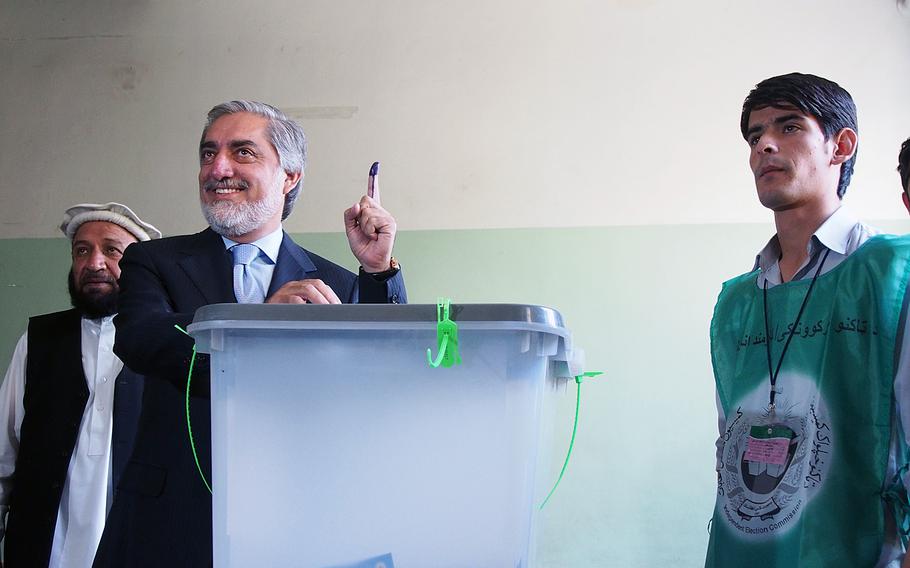 Afghan presidential candidate Abdullah Abdullah holds up an ink-stained finger after voting in Saturday's presidential election. Abdullah, a former foreign minister, is vying with former finance minister Ashraf Ghani to become Afghanistan's next president.
