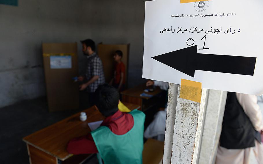 A sign directs voters to a polling location at a school in Kabul, Afghanistan. Afghans went to the polls in the second round of the presidential election on June 14, 2014.
