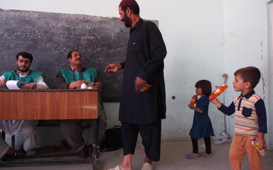 An Afghan man is trailed by his children as he prepares to vote in Afghanistan's presidential election Saturday in Kabul. A successful election would mark the first democratic transfer of power in the country's history. 