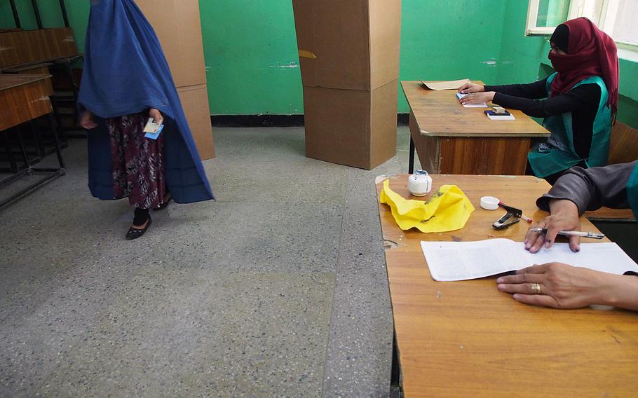A woman votes in the final round of Afghanistan's presidential election Saturday in Kabul. A successful election would mark the first democratic transfer of power in the country's history. 