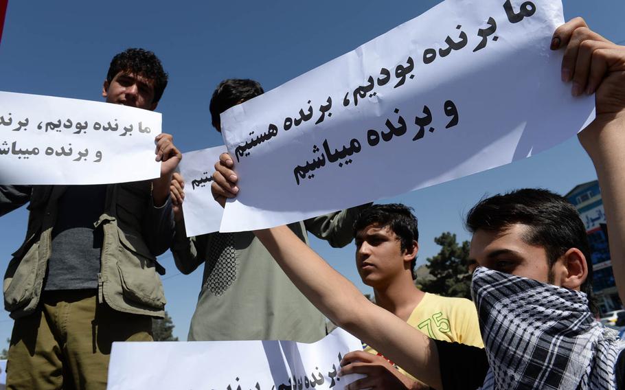 Supporters of Afghan presidential candidate Abdullah Abdullah hold signs at a demonstration in Kabul Saturday, June 21, 2014, to protest what they say was massive fraud in the June 14 presidential runoff. Abdullah says the election was marred by ballot stuffing and fraud, allegations some experts worry could weaken the next Afghan government.