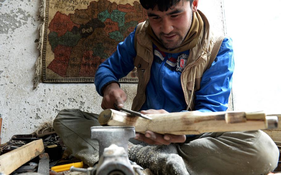 Nisar Ahmad, 22, carves the stock of a replica pistol in his workshop in Kabul. He says it can take up to a week to shape the stocks of larger guns like muskets and rifles.


