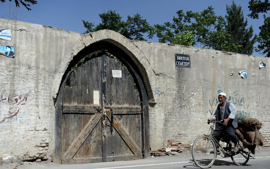 An man rides a bicycle past the gate of the British cemetery in Kabul. The cemetery originally held the remains of more than a hundred of the British soldiers and others who tried to occupy Kabul in the 19th century.

