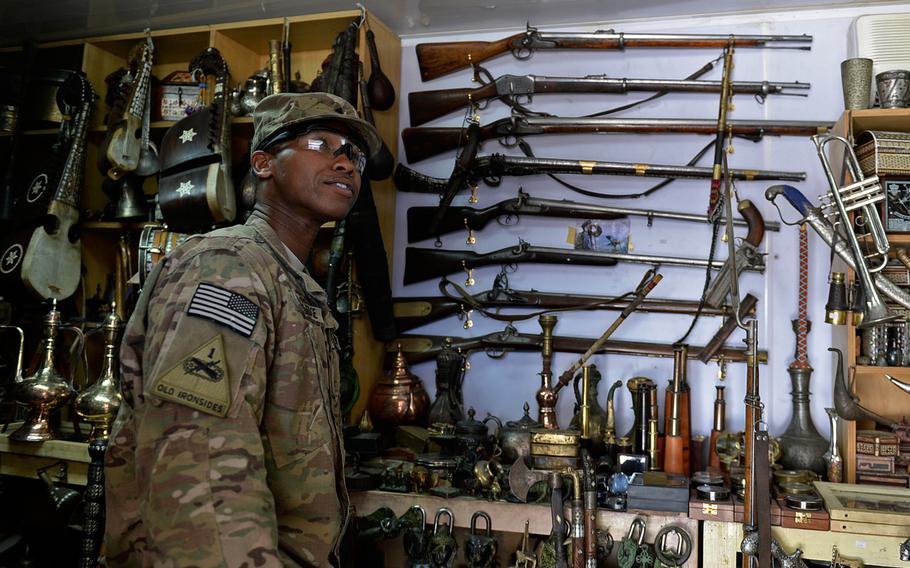 U.S. Army Sgt. Iraq Blackledge looks at knives and guns at an antique shop at Bagram Air Field in Afghanistan. He said he has been intrigued by the weapons but did not know until recently it was possible to mail such items back to the United States.

