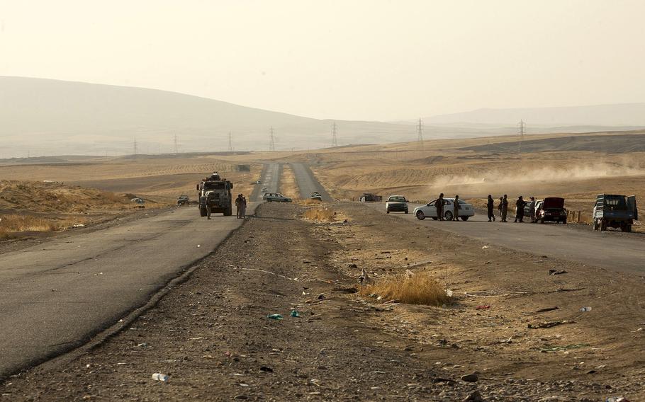 Abandoned cars that ran out of gasoline while fleeing the rapid advance of the Islamic State militants litter the final checkpoint on the highway on Aug. 7, 2014 near Kalak, Iraq. The militants' front lines lie about about one mile down the road from this point. 