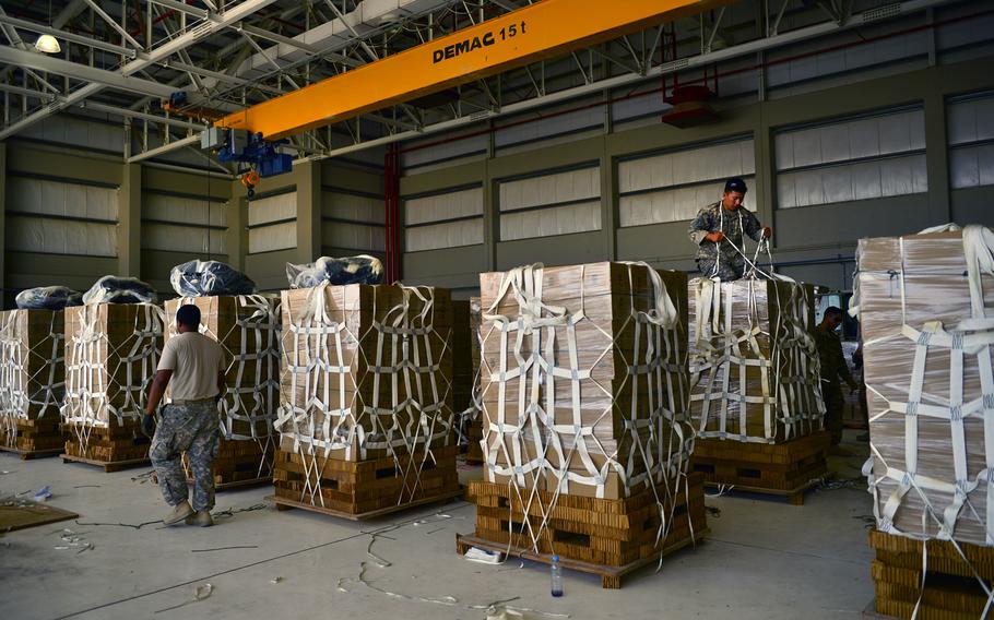 U.S. Army parachute riggers with the 11th Quartermaster Company, 264th Combat Sustainment Support Battalion, 82nd Sustainment Brigade palletize halal meals for a humanitarian airdrop Aug. 7, 2014, at an undisclosed location in Southwest Asia. 