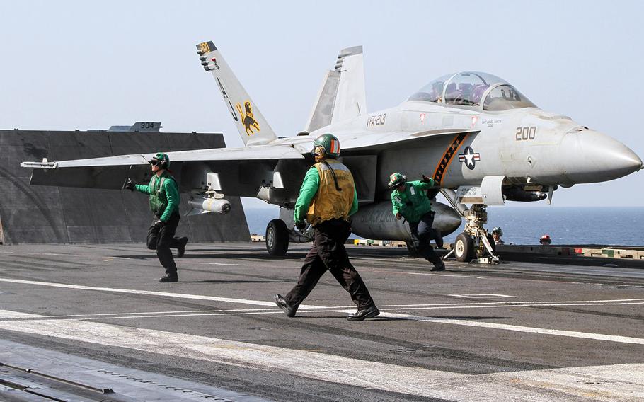 Flight Deck personnel clear the area around an F/A-18 Super Hornet, as it prepares to launch from the flight deck of the USS George H.W. Bush, underway in the Persian Gulf, Aug. 11, 2014.