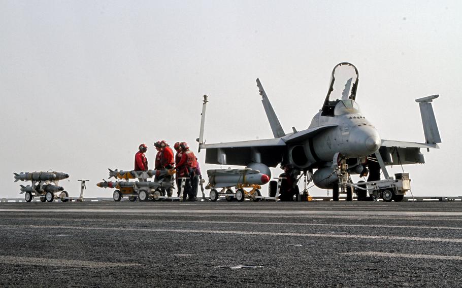 Aviation ordnancemen move bombs and missiles across the flight deck of  the USS George H.W. Bush, underway in the Persian Gulf, Aug 10, 2014. F/A 18s are among launched from the Bush are among aircraft conducting air strikes in Iraq.
