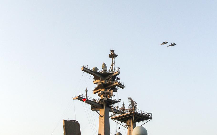 Two F/A 18 Super Hornets fly over the USS George H.W. Bush, underway in the Persian Gulf,  as they enter the flight pattern to land on the carrier, Aug 10, 2014. F/A 18s are among launched from the Bush are among aircraft  conducting air strikes in Iraq.
