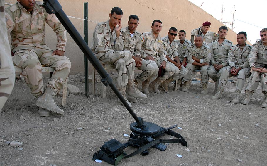 Soldiers with the 5th Iraqi Army Division in Diyala watch as one of their own shows how to use a metal detector to scan for hidden bombs and caches on Sept. 7, 2010. 