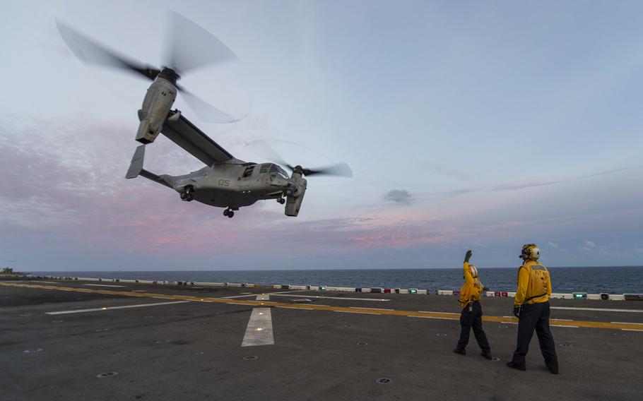 A Navy crewmember signals an MV-22 Osprey to launch from the flight deck of the amphibious assault ship USS Makin Island on Sept. 9, 2014, while the ship was underway in the Indian Ocean.