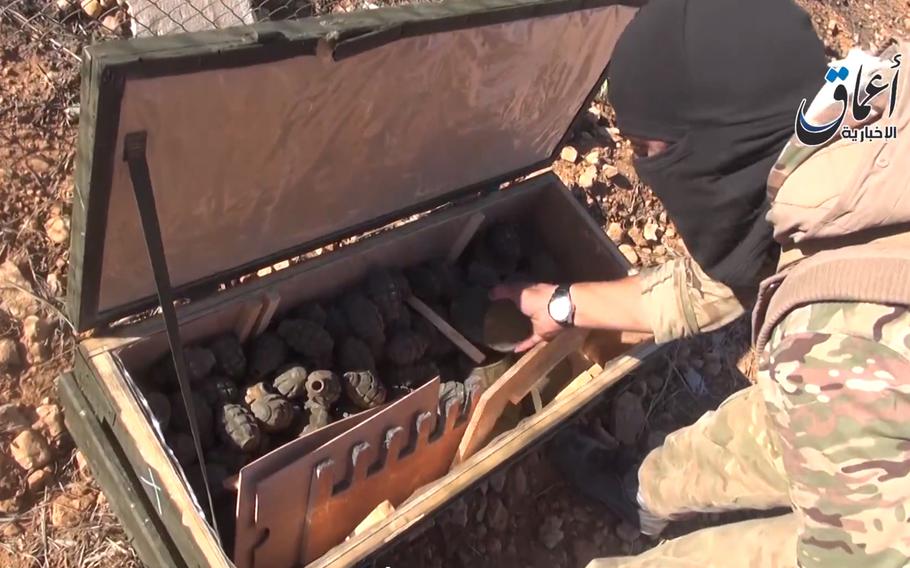 This frame grab from undated video uploaded by militants shows an Islamic State group militant looking through some items from a seized cache of weapons airdropped by U.S.-led coalition forces. The weapons were meant to supply Kurdish militiamen battling the extremist group in the Syrian town of Kobani, near the border with Turkey, activists said Tuesday, Oct. 21, 2014. The video appeared authentic and corresponded to The Associated Press' reporting of the event. 