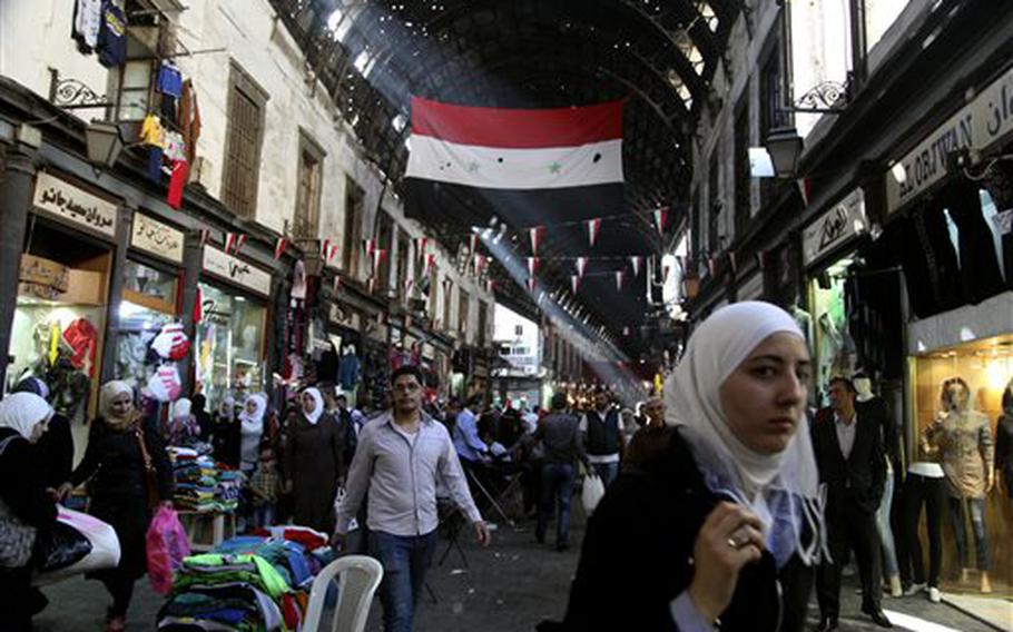 People shop in the ancient bazaar known as the Hamidiyeh souq in Damascus, Syria, Monday, Oct. 27, 2014. Even amid conflict, it's still an important shopping spot for the country’s working classes, but prices here have already quadrupled over the past four years for most products in the market.