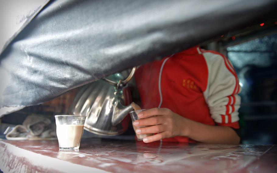 An Afghan man pours hot drinks for people gathered in the streets of Kabul to observe the day of Ashoura on Nov. 3, 2014. Such booths were set up on street corners around the city and served free drinks and candies.