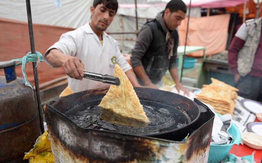 Afghan vendors prepare food for crowds gathered in the streets of Kabul to commemorate the day of Ashoura on Nov. 3, 2014. Heavy rain did not prevent hundreds of residents from attending the day's events.