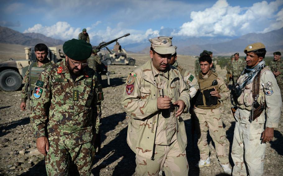 Afghan National Army Col. Hassani Kharokhel, left, and police Crisis Response Unit commander Rahm Khoda Mokhlis, center, discuss their plans during a joint clearing operation in Laghman province, Nov. 4, 2014. The restive province has seen ongoing low-level fighting between insurgents and government forces.


