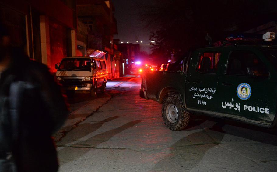 Police block off the street where a suicide attack on a foreign guest house in Kabul was followed by gunmen storming the building, Thursday, Nov. 27, 2014.