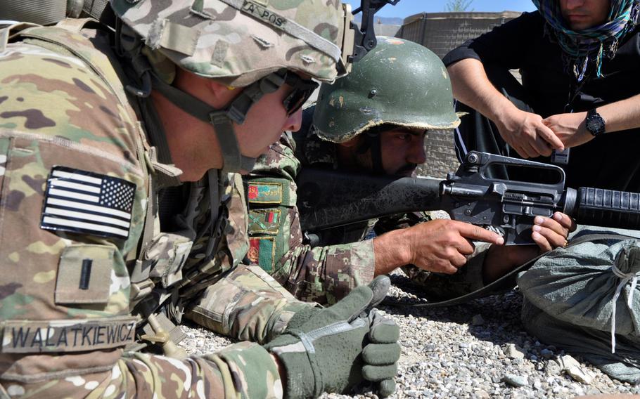 First Lt. Jon Walatkiewicz, an adviser with a 1st Brigade Combat Team, 101st Airborne Division Security Force Assistance Team, helps Afghan National Army soldier Hayakhan adjust and fire his M-16 rifle during training at Forward Operating Base Joyce in eastern Afghanistan on June 8, 2013.