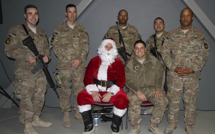 Soldiers gather at Bagram Air Field's MWR Theater in Afghanistan for a holiday celebration Dec. 24, 2014, where they enjoyed photos with Santa, a 'white elephant' gift exchange, food, a sing-off and a viewing of the movie 'National Lampoon's Christmas Vacation.'