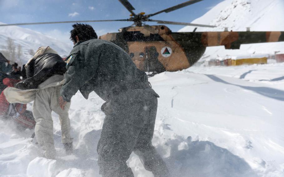 Afghan national policemen run toward an Afghan Air Force Mi-17 at a remote village in Panjshir province, Afghanistan, on Saturday, Feb. 28, 2015. Afghan security forces spent days helping search for bodies, evacuate wounded and resupply communities after heavy snowfall caused dozens of avalanches.

