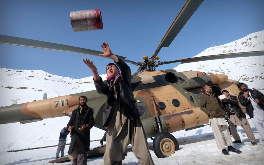 Community members help load an Afghan Air Force Mi-17 helicopter in Panjshir province, Afghanistan, with emergency supplies on Saturday, Feb. 28, 2015. Large swaths of the country were buried under heavy snow, which caused deadly avalanches, cut power lines and stranded many people.

