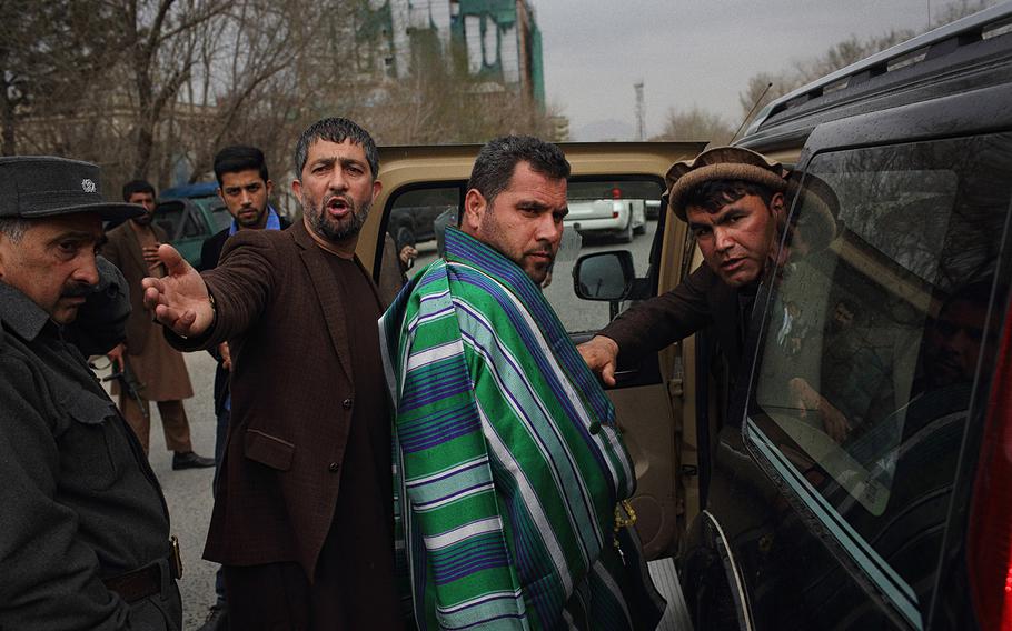 Najibullah Malikzadah, 37, center, is escorted by security officials after attending a condolence ceremony in a Kabul mosque on March 23, 2015. He is the elder brother of Farkhunda, who was beaten to death by a mob after being falsely accused of burning a Quran outside the Shah-do-Shamshira Mosque in central Kabul.