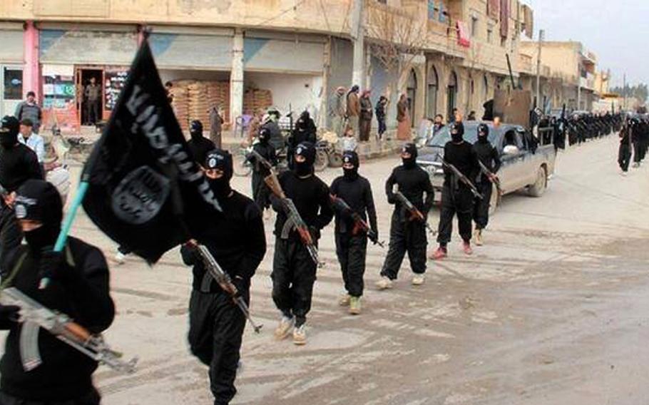 This undated file image posted on a militant website on Tuesday, Jan. 14, 2014 shows fighters from the al-Qaida linked Islamic State marching in Raqqa, Syria. 