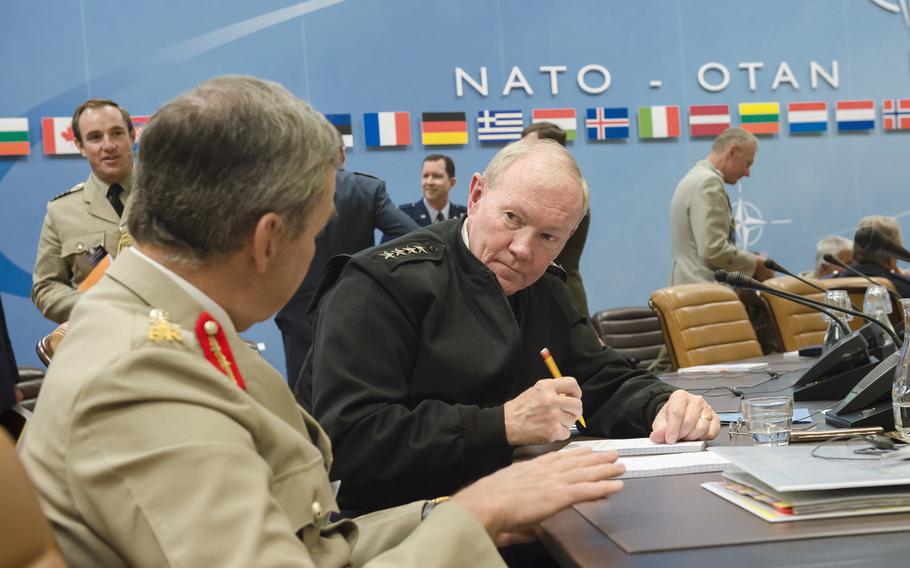 Joint Chiefs of Staff Gen. Martin E. Dempsey listens to Gen. Nicholas Houghton, Chief of the Defence Staff of the British Armed Forces, during the 173rd Military Committee in Chiefs of Defence Session at NATO headquarters in Brussels, Belgium, May 21, 2015. 