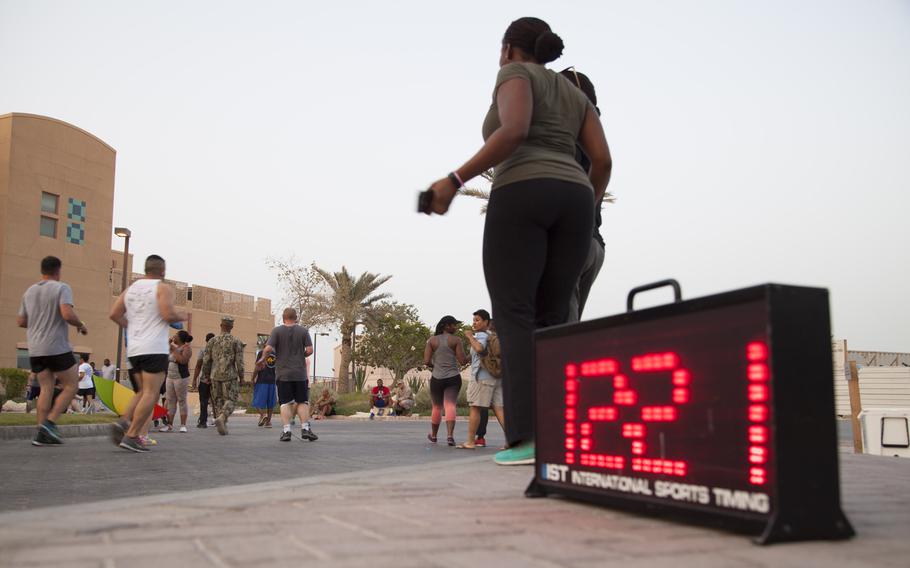 Runners cross the finish line of Naval Support Activity Bahrain's Pride Month three-kilometer race June 17, 2015.

