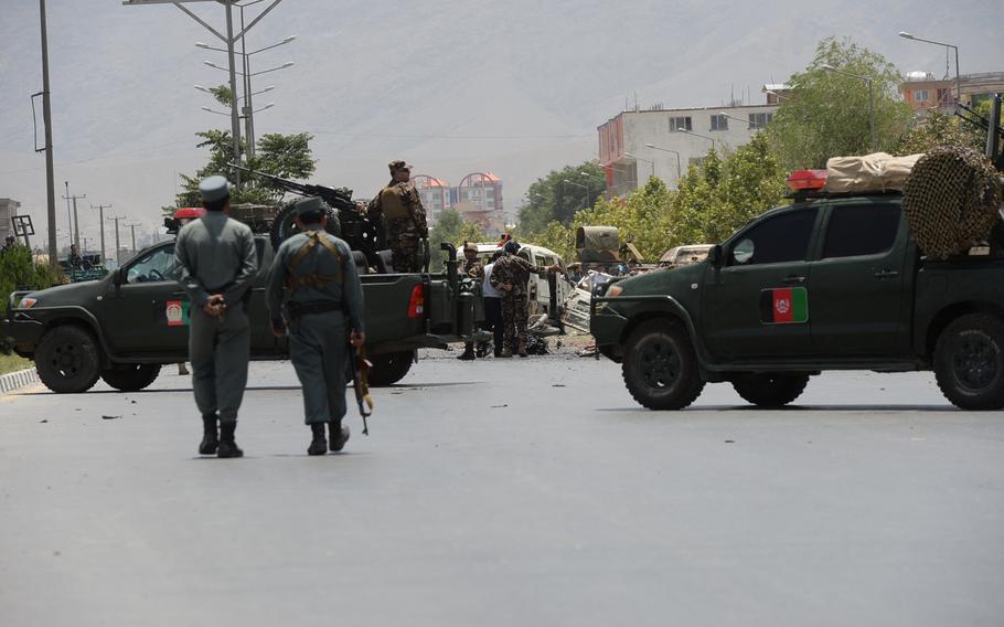 Members of the Afghan military and police survey the damage from several rocket-propelled grenades launched at the Parliament building during an  attack claimed by the Taliban on Monday, June 22, 2015.