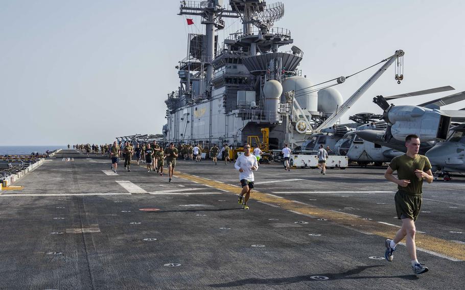 Sailors and Marines participate in a 5K run on the flight deck of the USS Essex on June 26, 2015. 