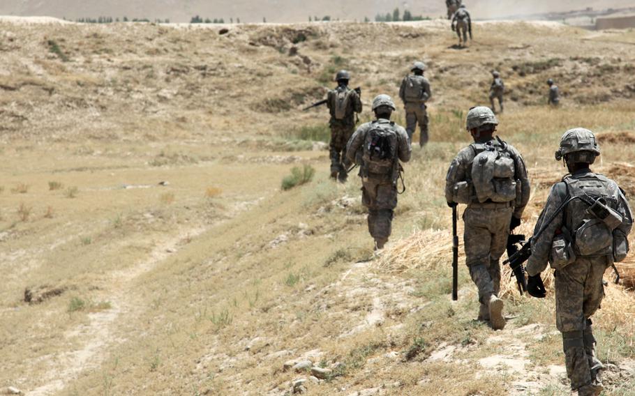 In this file photo taken July 6, 2011, U.S. Army and Afghanistan National Army soldiers patrol through the village of Baraki Barak, Logar province, Afghanistan, to clear a route and improve security in the area.