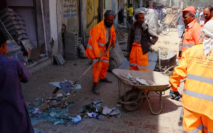 City workers clean up debris near the site of a large truck bomb that detonated early on Aug. 7, 2015 in Kabul. The explosion shattered windows and twisted metal for blocks.

