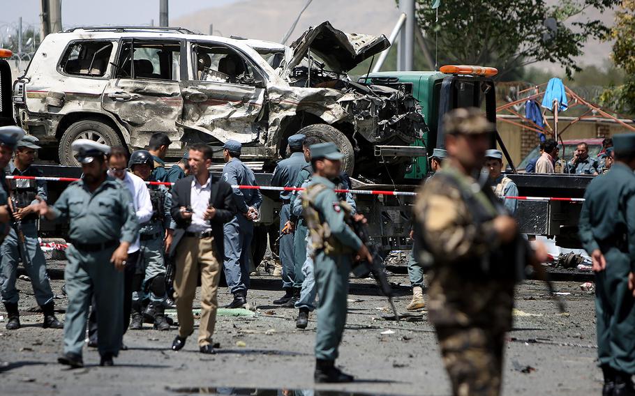 Afghan policemen inspect the site of a suicide car bombing in Kabul, Afghanistan, on Aug. 10, 2015. In another car bomb attack Saturday Aug. 22, 2015, at least 12 people were killed, Afghan officials said.