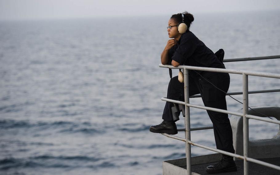 A sailor looks out at the sea while standing watch onboard the aircraft carrier USS Theodore Roosevelt on Aug. 13, 2015.  
