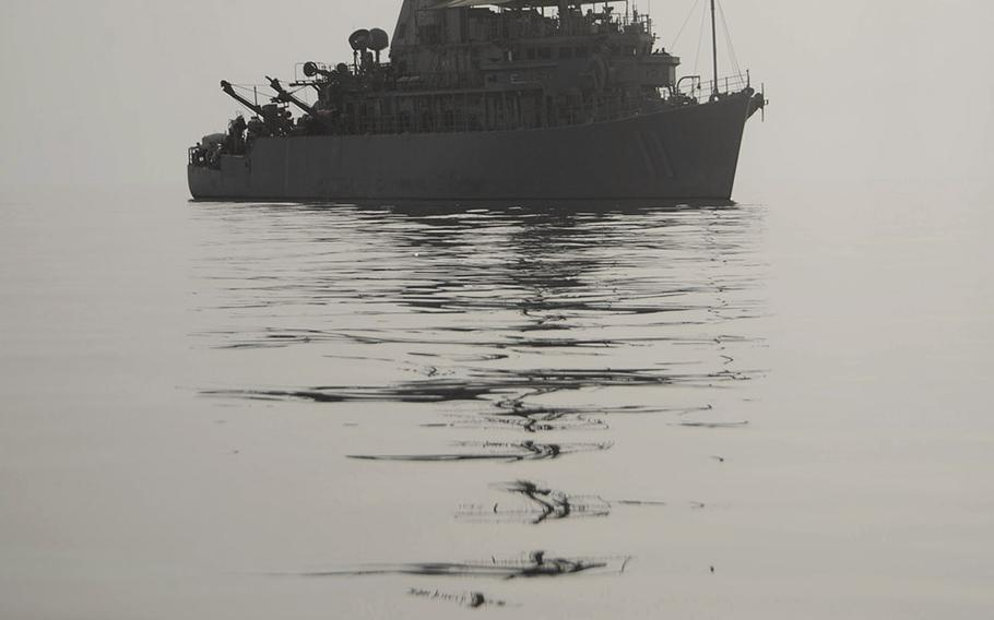 The Avenger-class mine countermeasures ship USS Gladiator assists members assigned to Explosive Ordnance Disposal Mobile Unit 1 in locating a training mine shape in this April 2010 photo.