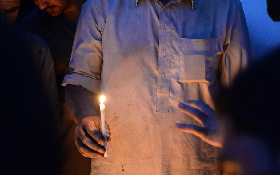 An Afghan man holds a candle at a vigil for people killed in multiple attacks on Aug. 7, 2015, in Kabul. The violence left more than 50 people dead and hundreds wounded.
