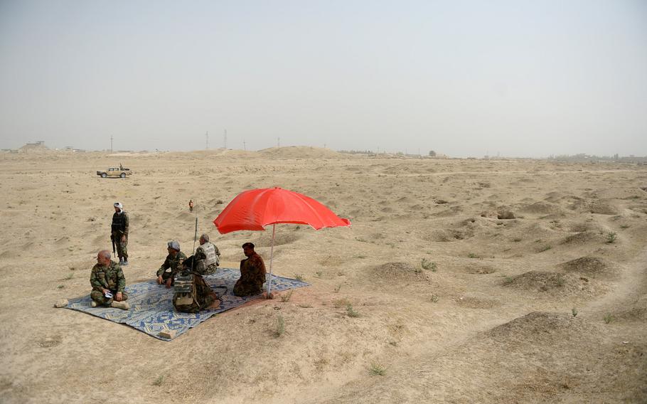 Headquarters staff for the Afghan army's 2nd Brigade, 209th Corps, set up a forward command post in a vast cemetery on the outskirts of Kunduz city during a clearing operation on Saturday, Oct. 10, 2015.


