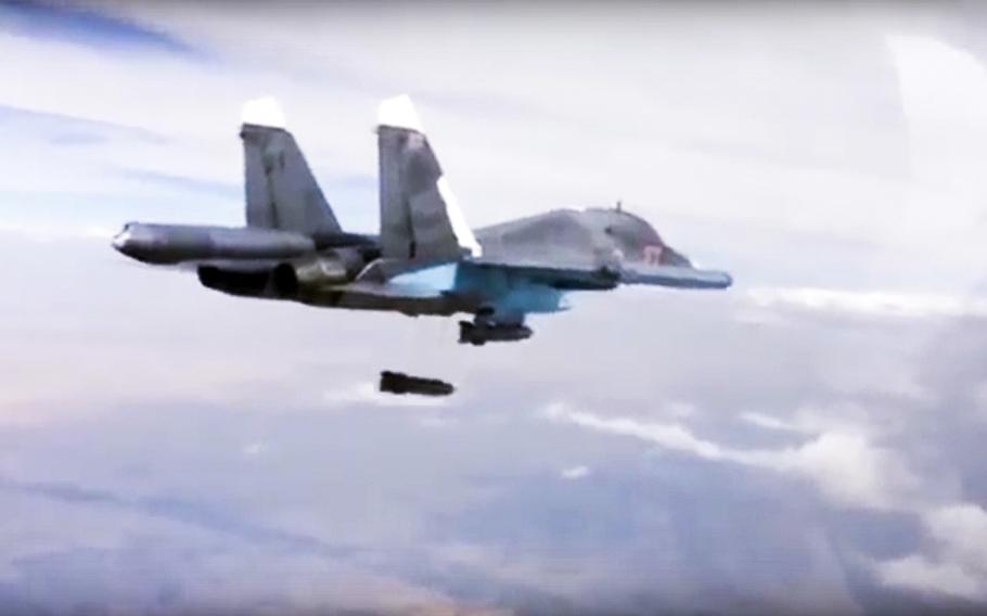 A video screen grab shows a Russian Su-34 bomber dropping bombs on a target.