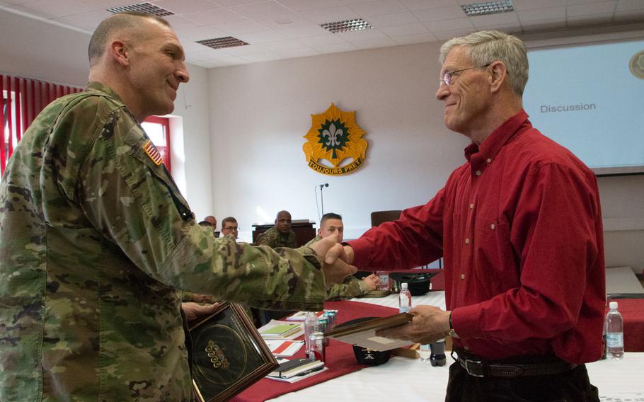 Retired U.S. Army Lt. Gen. Don Holder, right, former commander of the 2nd Armored Cavalry Regiment, shakes hands with Lt. Col. Steven Gventer, the current commander of the 2nd Squadron, 2nd Cavalry Regiment during a town hall meeting March 10, 2016 in Vilseck, Germany.