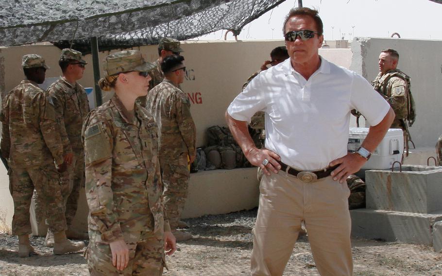 Arnold Schwarzenegger, the former governor of California, and 1st Lt. Alison Altz, a platoon leader with Company B, 82nd Brigade Engineer Battalion, talk about the TALON Robot and the Buffalo armored vehicle at Camp Arifjan, Kuwait, April 27, 2016. Schwarzenegger was in Kuwait to film a National Geographic documentary, "Years of Living Dangerously," focused on climate change. 

