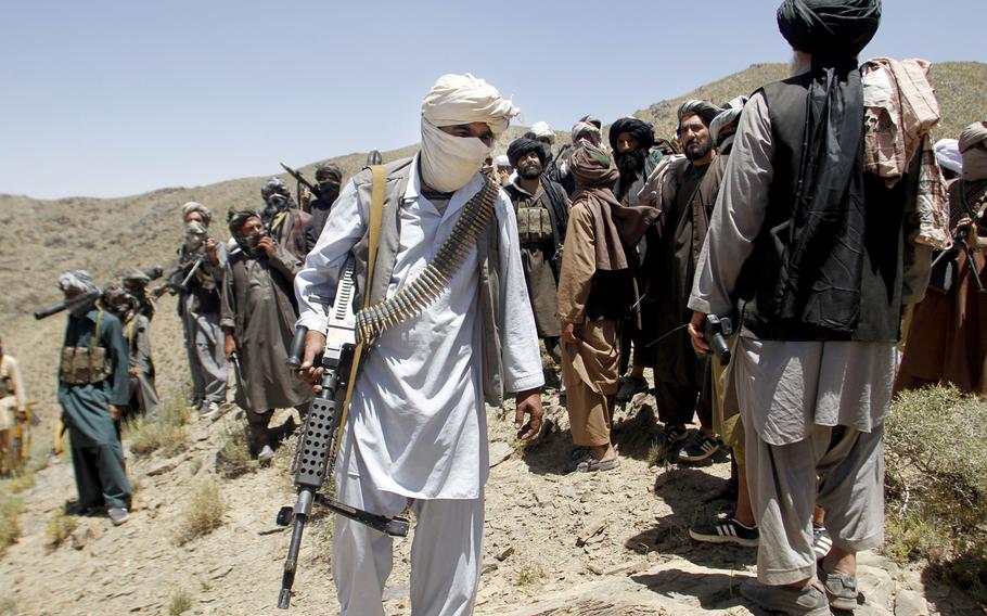 In this Friday, May 27, 2016 photo, members of a breakaway faction of the Taliban fighters walks during a gathering, in Shindand district of Herat province, Afghanistan. A string of coordinated Taliban attacks on police checkpoints in the increasingly volatile southern Afghan province of Helmand killed at least 12 policemen, an official said Monday.